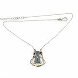 A blue/purple rectangular crystal is held in layers of sterling silver and bronze hammered wire pendant on sterling silver delicate chain necklace