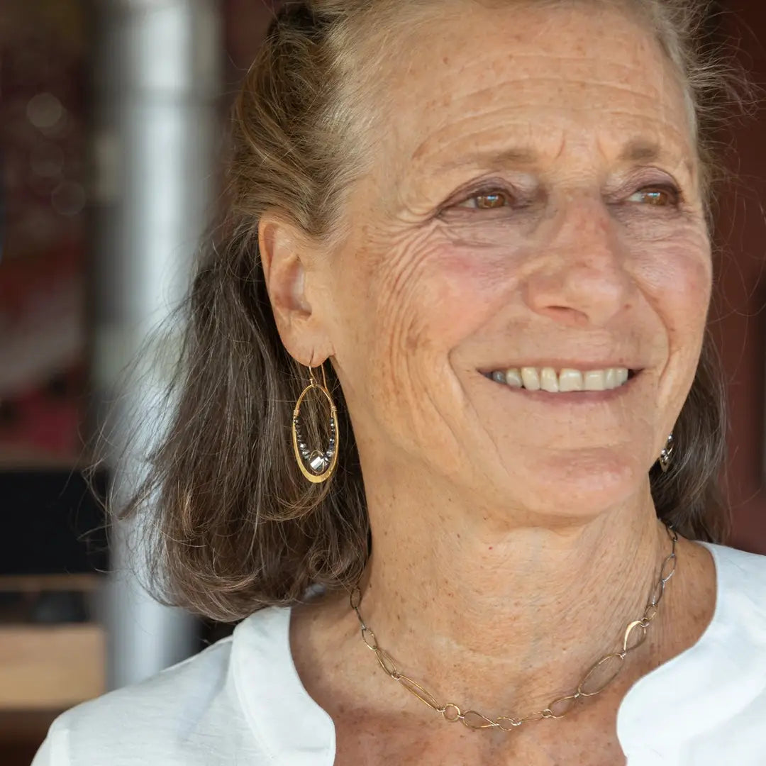 An artisanal chain necklace with a combination of handmade hammered brass links and open diamond cut oxidized sterling links 