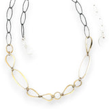 An artisanal chain necklace with a combination of handmade hammered brass links and open diamond cut oxidized sterling links 