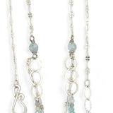 A sterling silver double strand necklace with chain links, twisted knot, amazonite, and aquamarine gemstones, featuring a blue rhomboid crystal pendant.