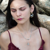 A sterling silver double strand necklace with chain links, twisted knot, amazonite, and aquamarine gemstones, featuring a blue rhomboid crystal pendant.