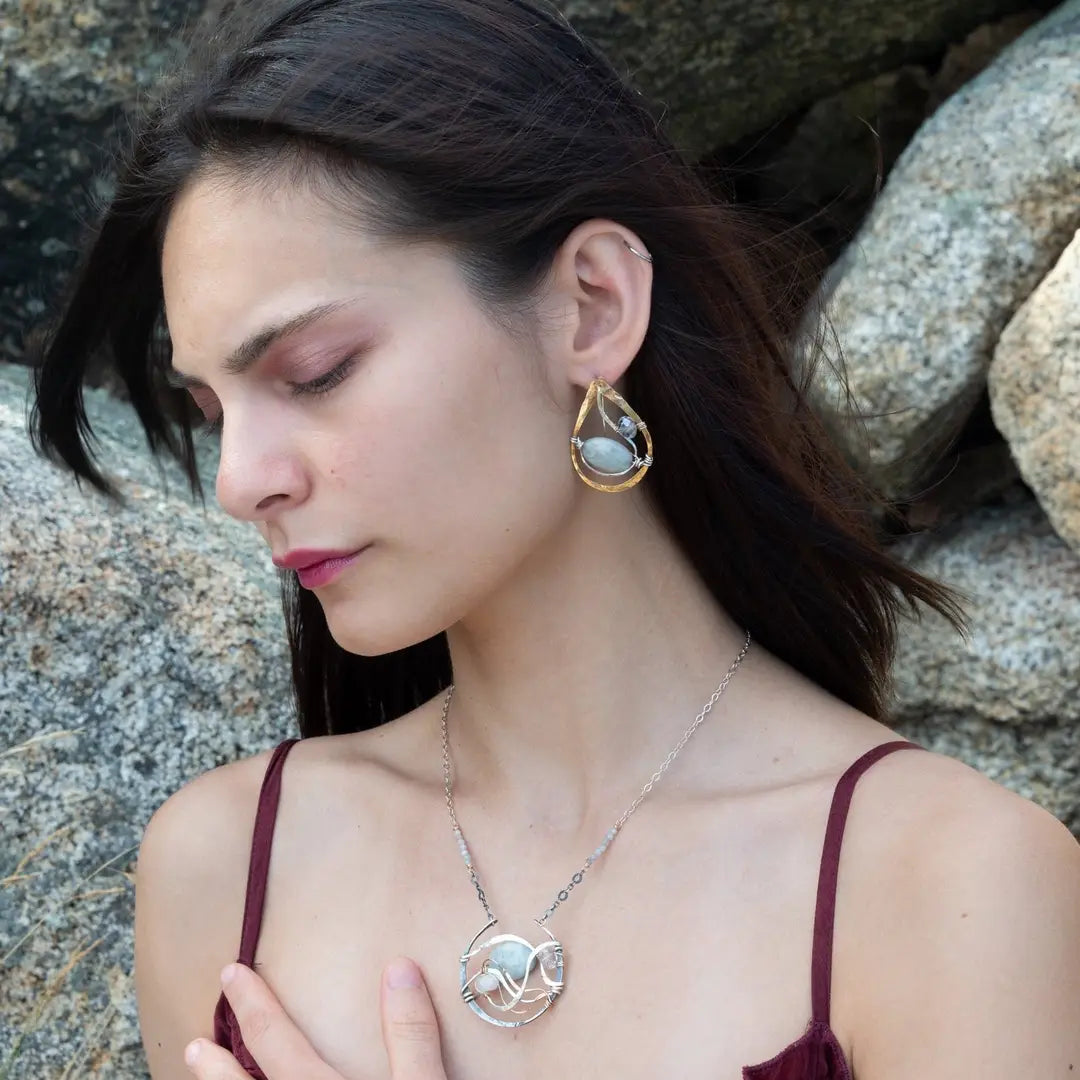 Aquamarine smooth oval gemstone earrings with a faceted blue crystal and wrapped in hammered sterling silver in a tree stamped brass drop earring with built in earring hooks that wear like a post earring