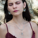 Aquamarine smooth oval gemstone earrings with a faceted blue crystal and wrapped in hammered sterling silver in a tree stamped brass drop earring with built in earring hooks that wear like a post earring