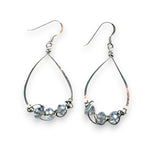 3 light blue crystals are wrapped up in sterling silver wire attached to the bottom of handmade sterling silver drop earrings