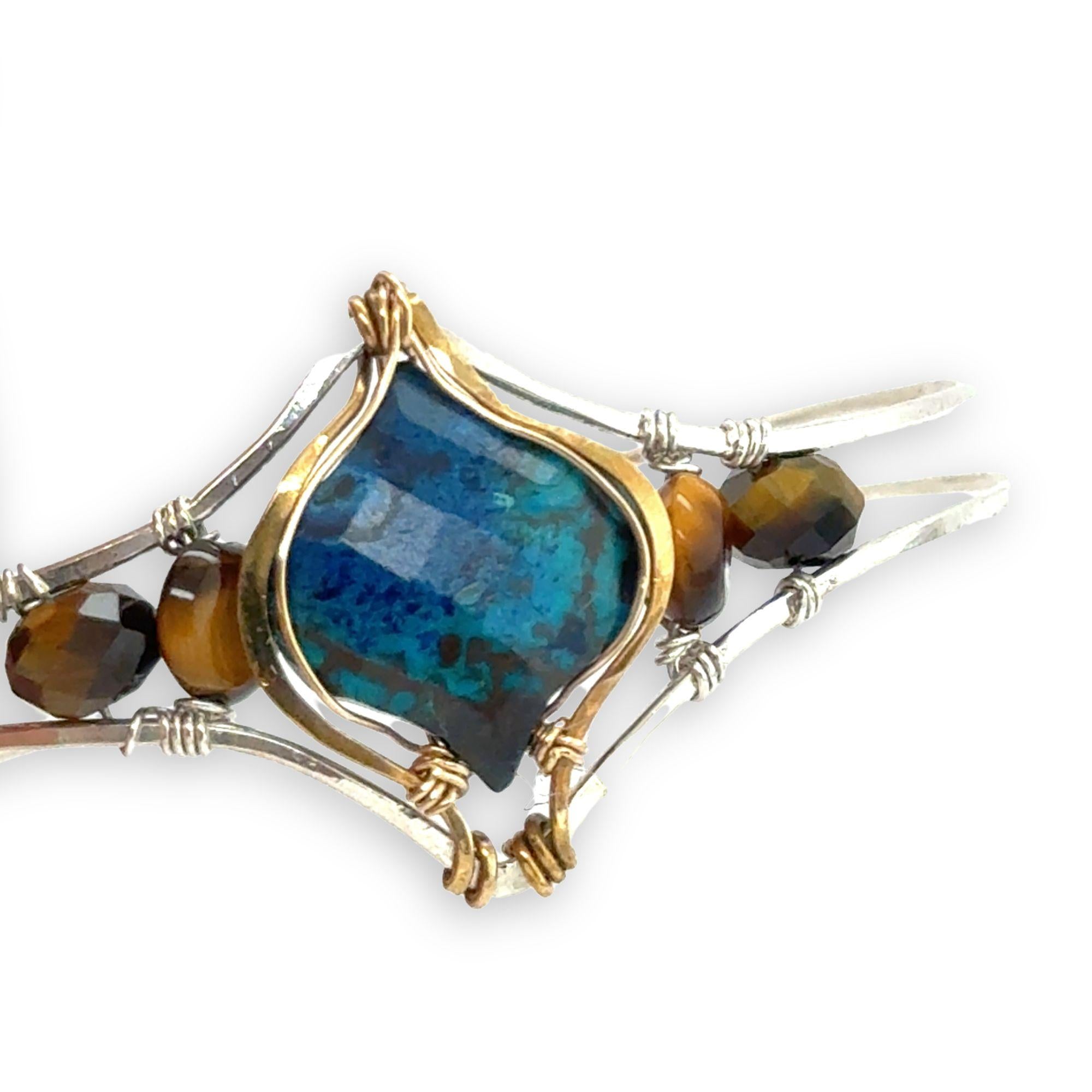 azurite teardrop gemstone at the center of sterling silver bracelet wrapped in brass hammered wire with tiger's eye accent