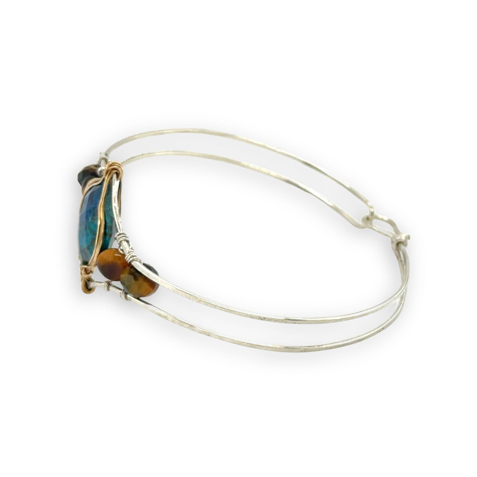 azurite teardrop gemstone at the center of sterling silver bracelet wrapped in brass hammered wire with tiger's eye accent