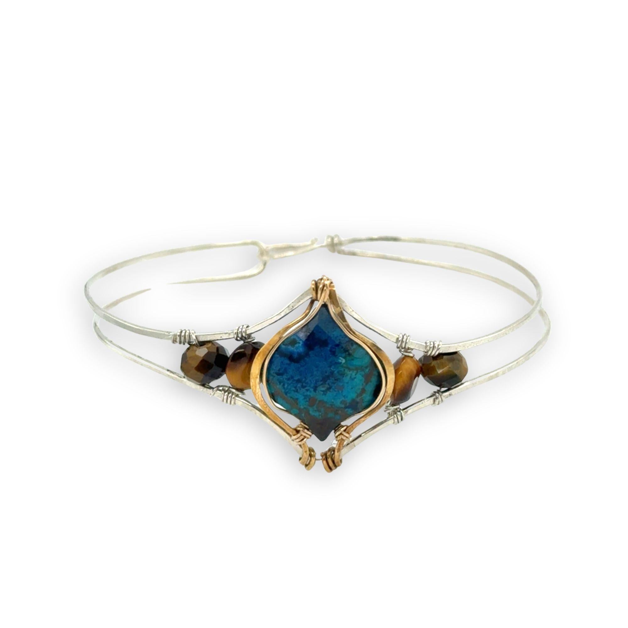 azurite teardrop gemstone at the center of sterling silver bracelet wrapped in brass hammered wire with tiger's eye accent