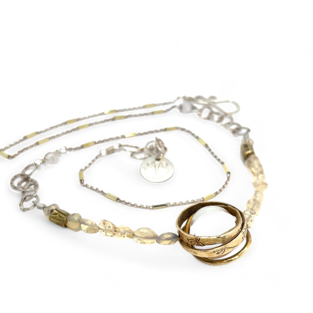 a fresh water pearl is held in a brass knot pendant with opal nugget gemstones on gold filled and sterling silver dash chain necklace