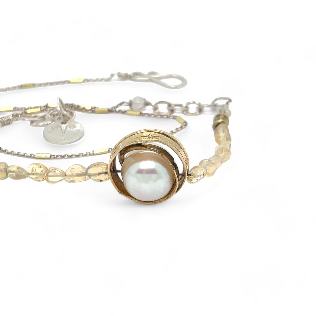 a fresh water pearl is held in a brass knot pendant with opal nugget gemstones on gold filled and sterling silver dash chain necklace