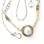 a fresh water pearl is held in a brass knot pendant with opal nugget gemstones on gold filled and sterling silver dash chain necklace