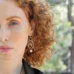 Mauve moonstone faceted coin gemstones are wrapped in brass twist wire attached to a sterling silver earring with a fresh water pearl dangle