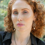 Mauve moonstone faceted coin gemstones are wrapped in brass twist wire attached to a sterling silver earring with a fresh water pearl dangle