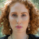 Mauve moonstone faceted coin gemstones are wrapped in brass twist wire attached to a sterling silver earring with a fresh water pearl dangle