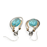 A pair of handcrafted oxidized sterling silver drop earrings with hammered brass, aqua blue quartz crystal centers and gold-filled details