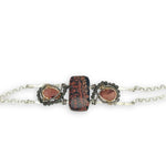 Red fossil jasper, rhodochrosite, and green obsidian gemstones fill the sterling silver bar bracelet with rolo chain backing