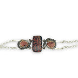 Red fossil jasper, rhodochrosite, and green obsidian gemstones fill the sterling silver bar bracelet with rolo chain backing