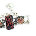 Red fossil jasper, rhodochrosite, and green obsidian gemstones fill the sterling silver bar bracelet with rolo chain backing