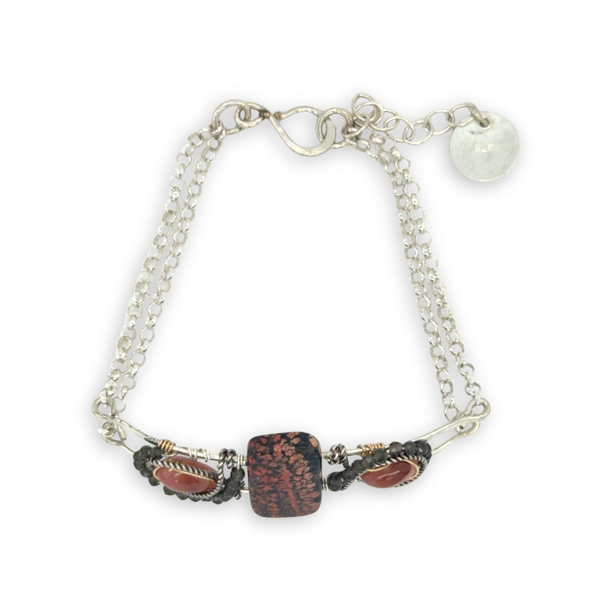 Red fossil jasper, rhodochrosite, and green obsidian gemstones fill the sterling silver bar bracelet with rolo chain backing