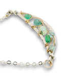 Double layered necklace with the first layer being sterling bar chain with blue opals, the second layer with a sterling moon shaped pendant filled with apatite and bold opal gemstones in 14k gold filled swirls