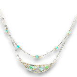 Double layered necklace with the first layer being sterling bar chain with blue opals, the second layer with a sterling moon shaped pendant filled with apatite and bold opal gemstones in 14k gold filled swirls