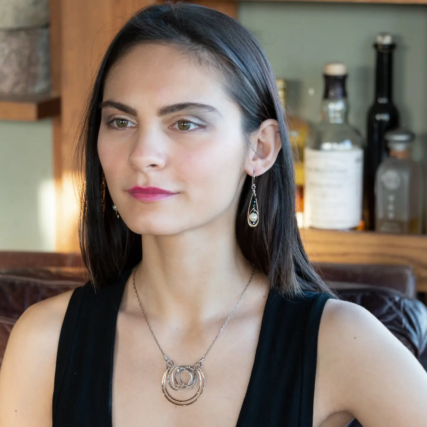 Green goldstone and round fresh water pearls are wrapped in gold filled wire attached to small sterling silver hammered drop earrings