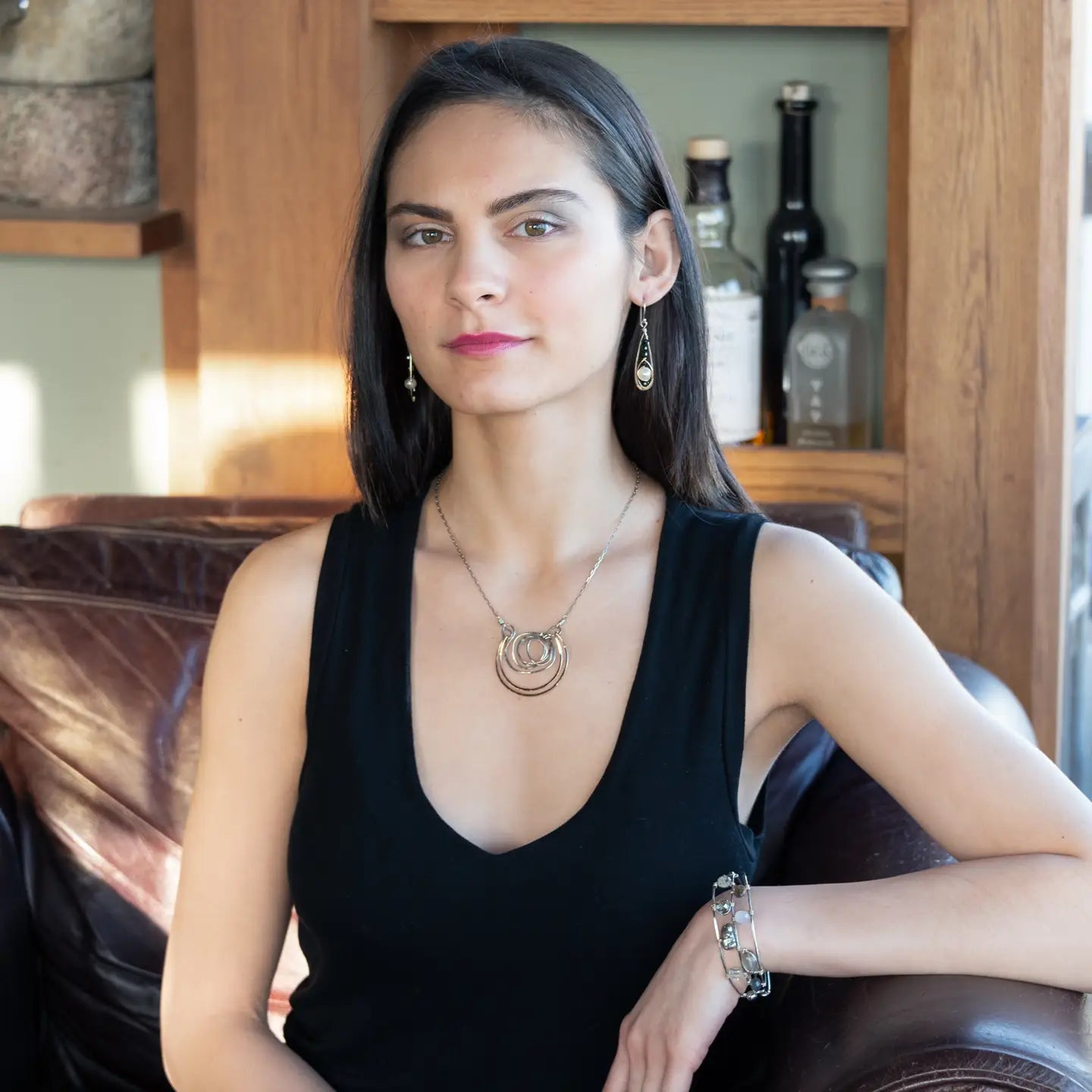 Green goldstone and round fresh water pearls are wrapped in gold filled wire attached to small sterling silver hammered drop earrings