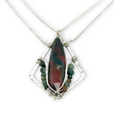 A hammered sterling silver diamond pendant hold a bloodstone faceted skinny drop accented with fancy jasper gemstones, held on a sterling silver dainty double chain necklace
