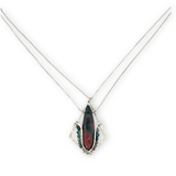 A hammered sterling silver diamond pendant hold a bloodstone faceted skinny drop accented with fancy jasper gemstones, held on a sterling silver dainty double chain necklace
