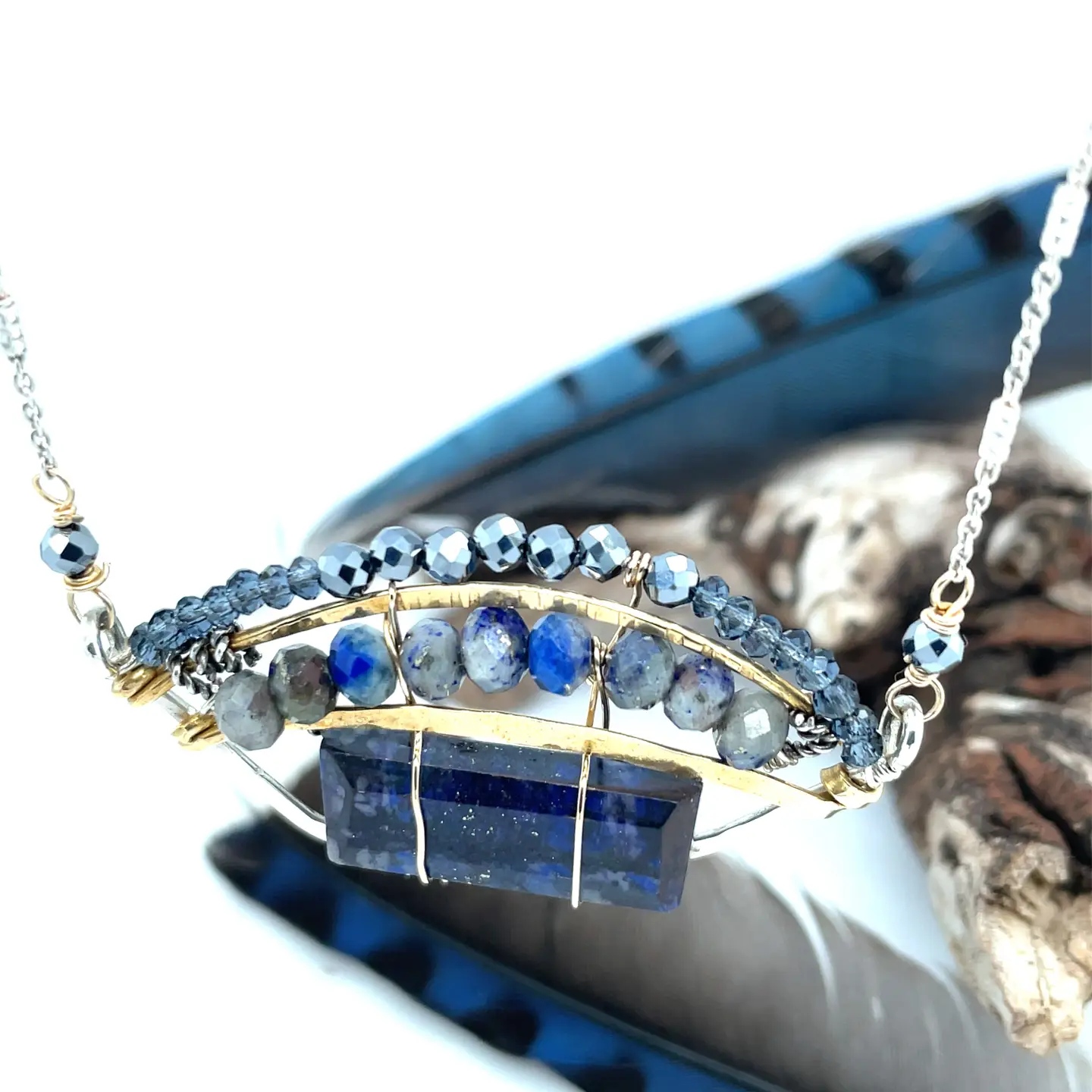 Lapis rectangle set into a sterling silver and brass blue jay pendant on a sparkly sterling silver dash chain. Accented with blue quartz, pyrite, and lapis gemstones held on with gold filled wire