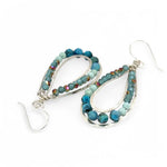 A pair of teardrop-shaped sterling silver channel earrings featuring blue opal and larimar gemstones with blue crystal