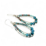 A pair of teardrop-shaped sterling silver channel earrings featuring blue opal and larimar gemstones with blue crystal