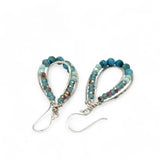 A pair of teardrop-shaped sterling silver channel earrings featuring blue opal and larimar gemstones with blue crystal