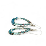 A pair of teardrop-shaped sterling silver channel earrings featuring blue opal and larimar gemstones with blue crystal