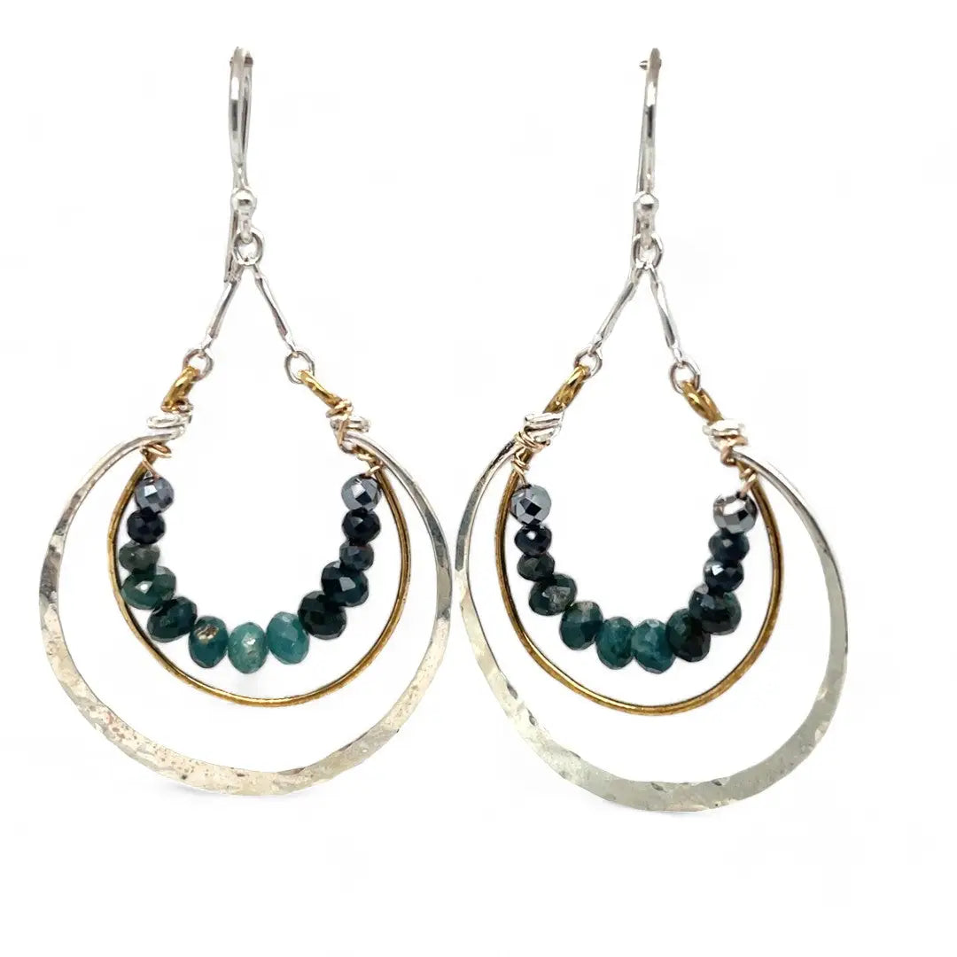 Blue tourmaline gemstones line the inside of a brass ring with hammered sterling silver outside ring, hanging from a sterling silver bar chain