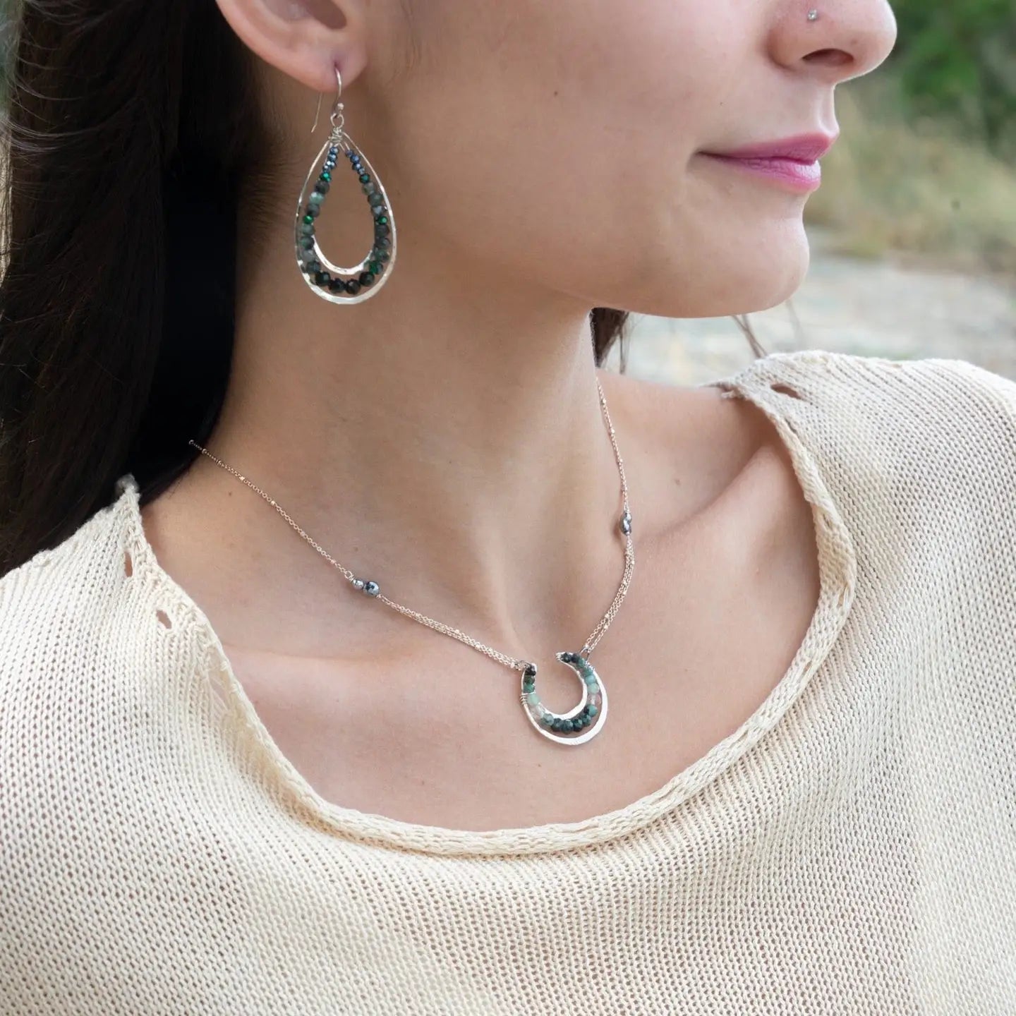 Mini sterling silver horseshoe shaped pendant filled with emerald, amazonite, blue tourmaline, and green amethyst gemstones, with a gold filled and sterling dot chain with pyrite accents necklace