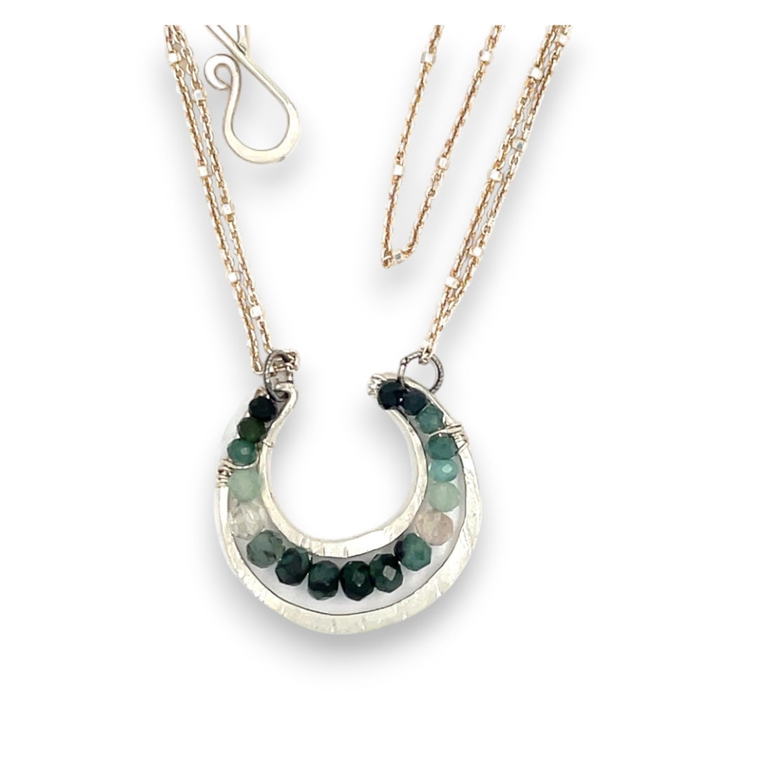 Mini sterling silver horseshoe shaped pendant filled with emerald, amazonite, blue tourmaline, and green amethyst gemstones, with a gold filled and sterling dot chain with pyrite accents necklace