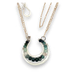 Mini sterling silver horseshoe shaped pendant filled with emerald, amazonite, blue tourmaline, and green amethyst gemstones, with a gold filled and sterling dot chain with pyrite accents necklace