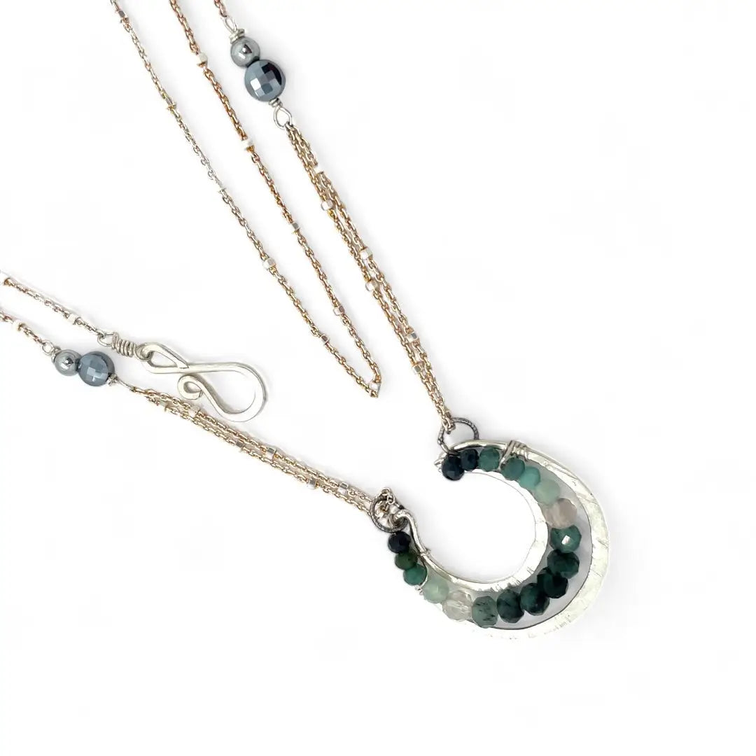 Mini sterling silver horseshoe shaped pendant filled with emerald, amazonite, blue tourmaline, and green amethyst gemstones, with a gold filled and sterling dot chain with pyrite accents necklace