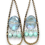 A pair of twisted brass drop earrings featuring blue crystal, amazonite and apatite gemstones 