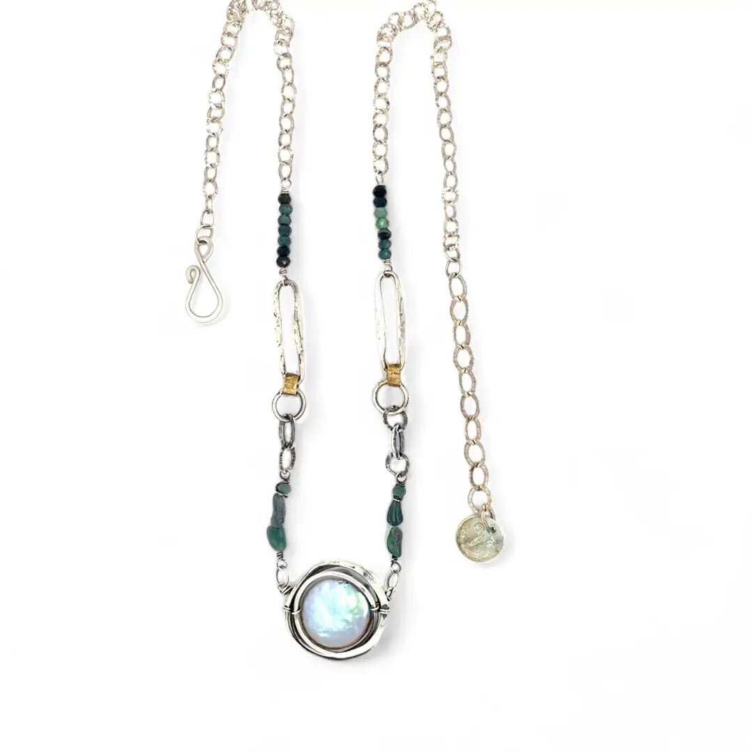 A sterling silver chain link necklace with a blue purple fresh water pearl coin in a hammered silver knot pendant, accented with blue opal and blue tourmaline gemstones