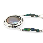A sterling silver chain link necklace with a blue purple fresh water pearl coin in a hammered silver knot pendant, accented with blue opal and blue tourmaline gemstones