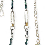 A sterling silver chain link necklace with a blue purple fresh water pearl coin in a hammered silver knot pendant, accented with blue opal and blue tourmaline gemstones