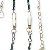 A sterling silver chain link necklace with a blue purple fresh water pearl coin in a hammered silver knot pendant, accented with blue opal and blue tourmaline gemstones