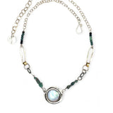 A sterling silver chain link necklace with a blue purple fresh water pearl coin in a hammered silver knot pendant, accented with blue opal and blue tourmaline gemstones