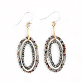 A pair of drop earrings featuring micro faceted blush crystals in two rows around a hammered silver ring, with bronze stems and French hooks.