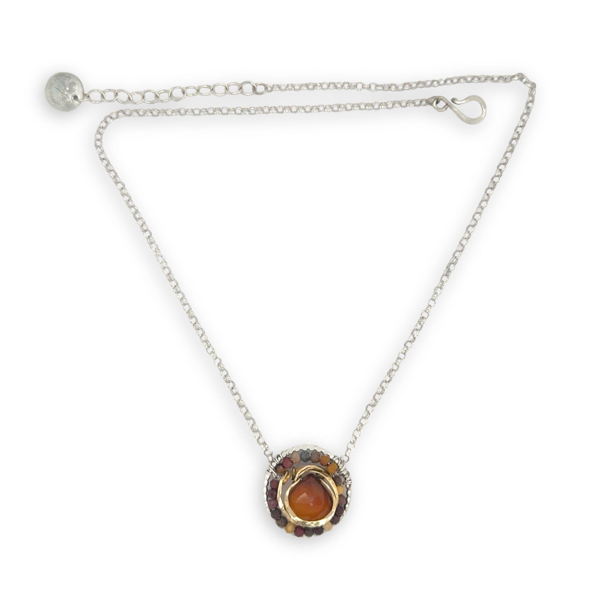 Necklace with a circular pendant featuring a central honey chalcedony stone and smaller mookaite jasper gemstones surrounding brass hammered wire