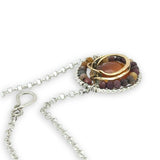 Necklace with a circular pendant featuring a central honey chalcedony stone and smaller mookaite jasper gemstones surrounding brass hammered wire