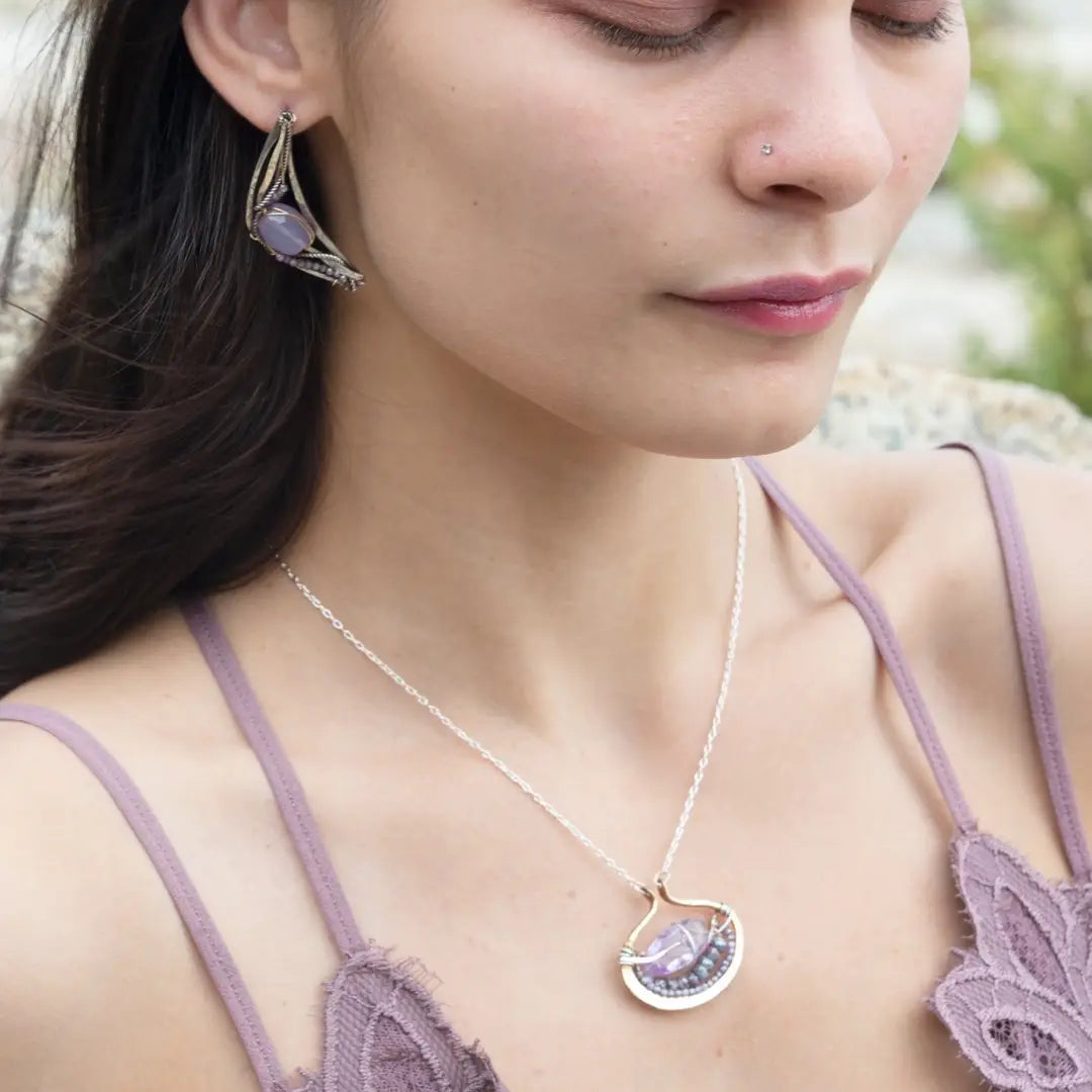 A pair of lavender jade faceted electric gemstone wrapped in gold-filled and set in sterling silver twist oxidized handmade boomerang post style earrings.