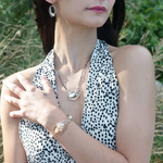 Sterling, darkened sterling, and bronze hammered waves form a cuff bracelet accented with moonstone, opal, fresh water pearl, and prehnite gemstones on gold filled wire