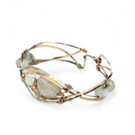 Sterling, darkened sterling, and bronze hammered waves form a cuff bracelet accented with moonstone, opal, fresh water pearl, and prehnite gemstones on gold filled wire